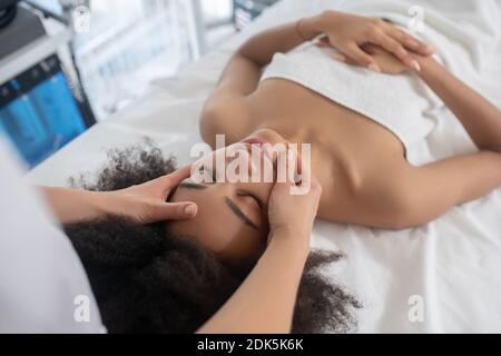 Mädchen und Kosmetikerin tun Gesichtsmassage Stockfoto