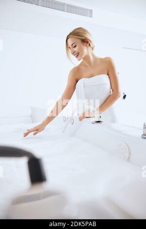 Happy fröhlich hübsche Frau in weißem Handtuch genießen tolles Wochenende Im Spa Resort Stockfoto