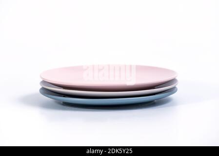 Stapel von drei bunten leeren Platten isoliert auf weißem Hintergrund, Seitenansicht. Navy Blue, Grey und Pink Empty Plates Kollektion Stockfoto