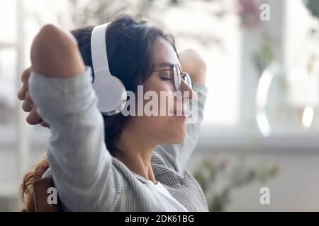 Hübsche junge Frau trägt moderne Kopfhörer-Set Musik hören Stockfoto