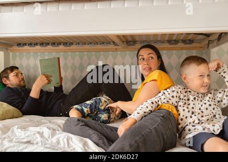 Parents with sons on bed Stockfoto