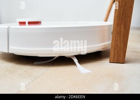 Roboter-Staubsauger Arbeiten auf dem Boden mit Möbeln, Hindernisse für Roboter-Staubsauger. Moderner, intelligenter Haushalt Stockfoto