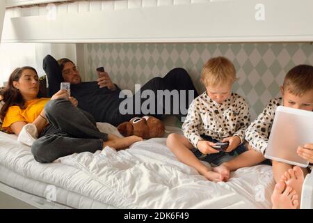 Parents with sons on bed Stockfoto