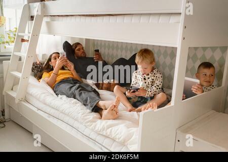 Parents with sons on bed Stockfoto