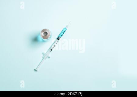 Spritzen mit blauer Medizinflüssigkeit auf einem isolierten blauen festen Hintergrund. Impfungs-, Immunitäts- oder Kosmetologiekonzept Stockfoto