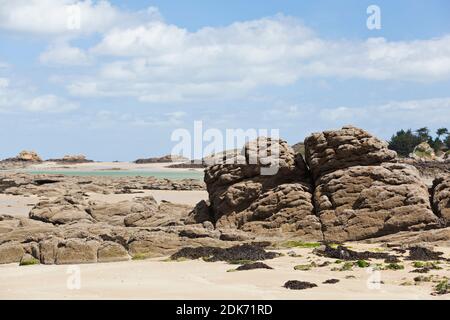 Rocks and beach form the tidal island of Ebihens near Saint Malo in Brittany, France. Stock Photo