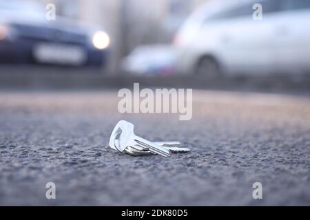 Schlüsselbund liegt auf der Straße auf dem Parkplatz. Key Recovery Service Konzept Stockfoto