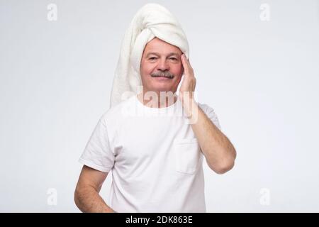 Reifer Mann mit Creme für Gesichtshaut. Studioaufnahme Stockfoto