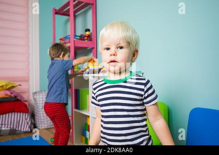 Im Kindergarten spielen die Kinder abwechselnd mit Spielzeug Stockfoto