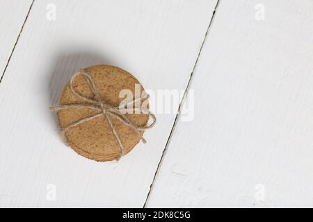 Lebkuchenkekse mit Garn gebunden. Auf Brettern weiß lackiert. Nahaufnahme. Stockfoto