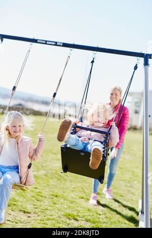 Mädchen auf Spielplatz Schaukeln Stockfoto