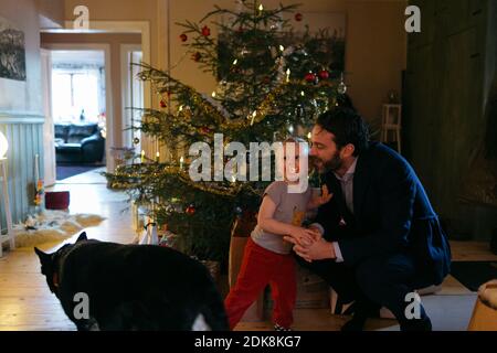 Vater mit Kleinkind Sohn vor Weihnachtsbaum Stockfoto