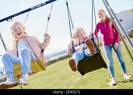 Mädchen auf Spielplatz Schaukeln Stockfoto