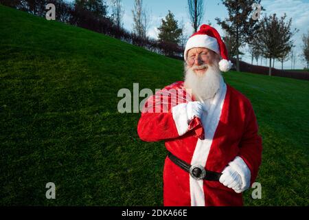 Lustiger Weihnachtsmann trägt rotes Kostüm in Brille im Stehen Auf der Straße Stockfoto