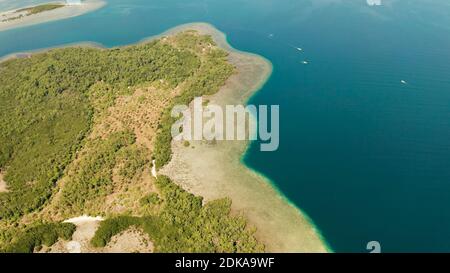 Tropische Insel mit Mangroven umgeben von einem Korallenriff und blauem Meer. Luftaufnahme Stockfoto