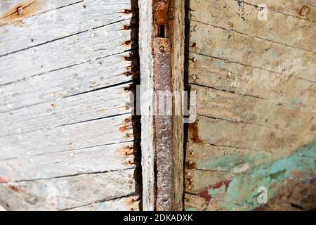 Detail eines alten Holzschiffes Rumpf mit Farbrückständen und Rost. Portbail Hafen, Normandie, Frankreich Stockfoto