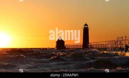 Grand Haven South Pier Leuchtturm bei Sonnenuntergang am Lake Michigan, an einem windigen Tag Stockfoto