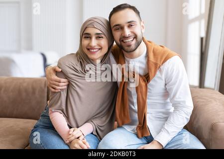 Happy Muslim Paar Umarmt Sitzen Zusammen Auf Der Couch Zu Hause Stockfoto