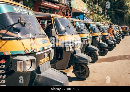 A row of parked colorful tuk-tuk auto rickshaws in Munnar, Kerala, India Stock Photo