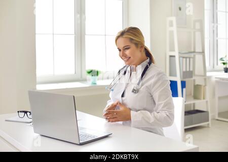 Lächelnder Arzt, der während eines Videoanrufs dem Patienten Gesundheitsberatung gibt Auf einem modernen Laptop Stockfoto