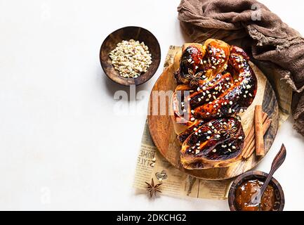 Babka oder Brioche Brot mit Aprikosenmarmelade und Nüssen. Hausgemachtes Gebäck zum Frühstück. Konkreter Hintergrund. Draufsicht. Speicherplatz kopieren. Stockfoto