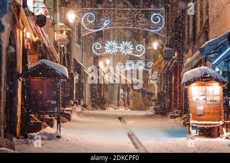 Winterzauber weihnachten geschmückt europäischen Straße mit verschwommenen Schneeflocken am Abend. Frohe Weihnachten. Atmosphäre in der Nacht zum Neujahr. Frankreich - Dezember Stockfoto