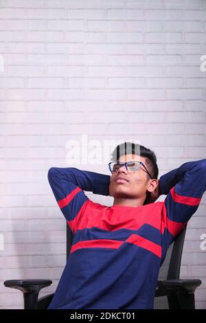 Trauriger junger Mann sitzt allein auf einem Stuhl Stockfoto