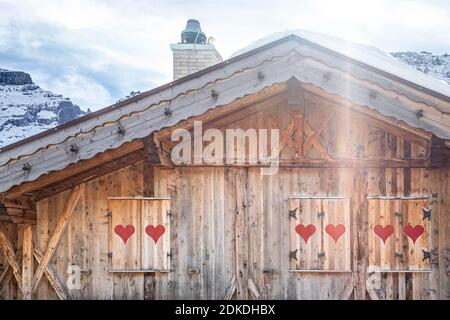 Holzgebäude im alpinen Stil mit Fensterläden mit roten Herzen, dolomiten, belluno, italien Stockfoto