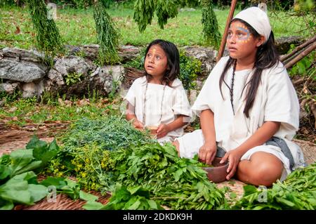 Glückliche indische Kinder im Maya Dorf. Junge Mädchen sitzen auf Matten während einer Maya-Zeremonie, Mexiko Stockfoto