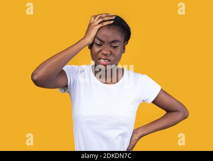 Afroamerikanische Frau, Die Unter Starken Kopfschmerzen Leidet, Gelber Hintergrund Stockfoto