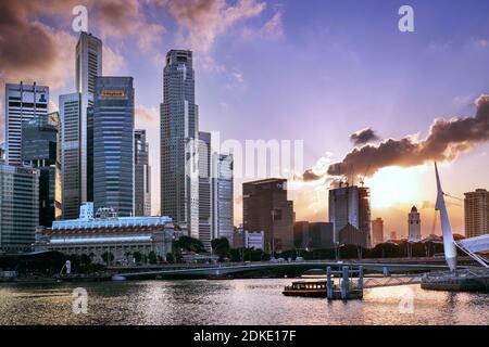 Marina Bay mit Fullerton Hotel und Wolkenkratzern in Singapur Sonnenuntergang Stockfoto