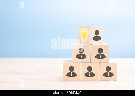Leader mit Idee und Innovation, Flips Würfel mit Symbol Glühbirne und menschliches Symbol. Corporate Hierarchie und neue Idee Konzept. Blauer Hintergrund. Copy Spa Stockfoto