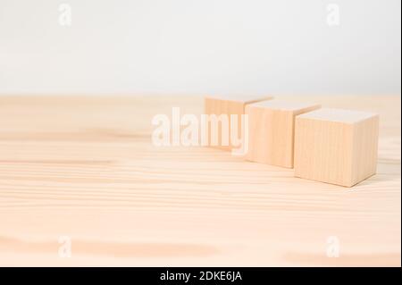 Drei Holzwürfel für Ihren Text, Symbole, Zeichen und Symbole, um Ihre kreativen Konzepte zu erstellen. Mock up blank Holzwürfel. Blöcke auf Holztisch Stockfoto