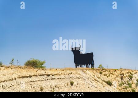 Zeichen eines schwarzen spanischen Stiers in der Wüste mit blau Himmel und Sträucher an einem Sommertag Stockfoto