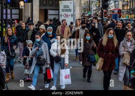 London, Großbritannien. Dezember 2020. Die meisten Käufer tragen Masken, auch außerhalb - Oxford Street, am Vorabend von Tier 3, und Käufer sind jetzt die Geschäfte sind wieder geöffnet. Aber dies sind immer noch schwierige Zeiten für Einzelhändler, da sie versuchen, nach der zweiten Coronavirus-Sperre aufzuholen und die Reaktion auf Tier 3 für London unklar ist. Kredit: Guy Bell/Alamy Live Nachrichten Stockfoto