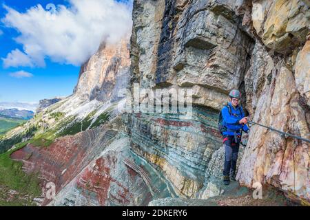 Junger Mann mit 22 Jahren auf dem gut ausgerüsteten Weg Astaldi (charakteristisch für farbige Felsen) an den Fussen von Tofane, Cortina d'Ampezzo, Dolomiten, Belluno, Venetien, Italien Stockfoto