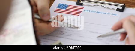 Mann mit Pass und Dollar Punkte mit Stift an Dokumenten Im Ordner der Botschaft Nahaufnahme Stockfoto