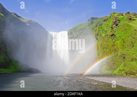 Skogafoss, 63 m hoher Wasserfall am Fluss Skógá mit doppeltem Regenbogen im Sommer, Skógar, Island Stockfoto