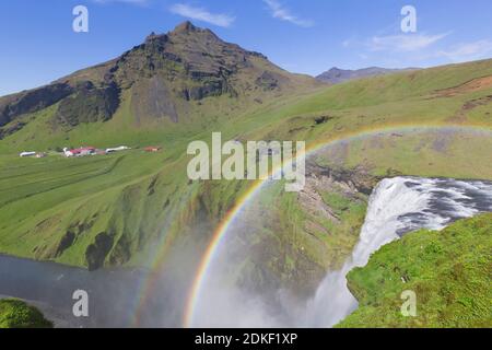 Skogafoss, 63 m hoher Wasserfall am Fluss Skógá mit doppeltem Regenbogen im Sommer, Skógar, Island Stockfoto