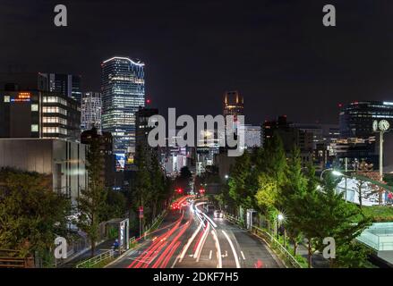tokio, japan - november 02 2019: Nachtansicht mit Autoscheinwerfern auf der Fire Street, die von Harajuku nach Shibuya mit den neuen Wolkenkratzern führt Stockfoto