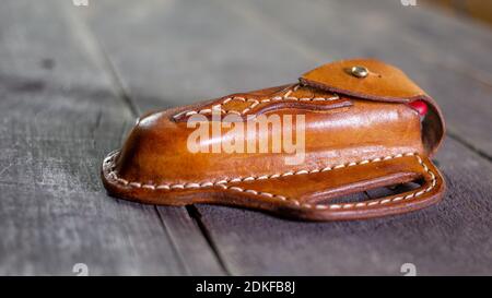 Handgemachte Leder Pfannkuchen Messer Mantel auf Holzhintergrund. Von Hand genäht. Stockfoto