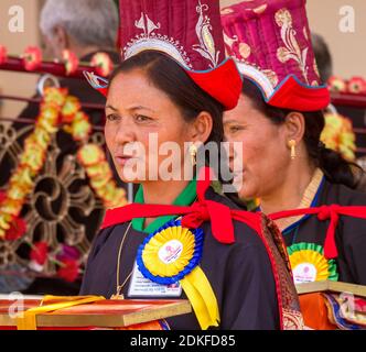 Leh, Indien - 7. August 2012: Frau in nationaler Kleidung sorgfältig und verantwortungsvoll führt ihre Pflichten bei der seine Heiligkeit der 14. Dalai Lama Lehren A Stockfoto