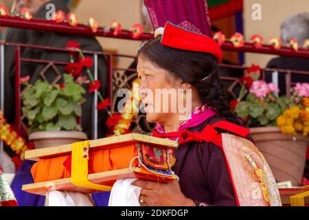 Leh, Indien - 7. August 2012: Frau in nationaler Kleidung sorgfältig und verantwortungsvoll führt ihre Pflichten bei der seine Heiligkeit der 14. Dalai Lama Lehren A Stockfoto