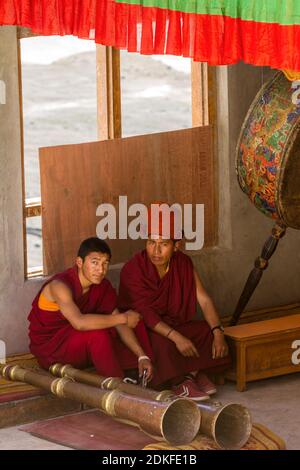 Karsha, Zanskar, Indien - 17. Juli 2012: Zwei musitianische Mönche mit den tibetischen Hörnern (Dungchen) und rituellen Trommeln, die während einer Pause im heiligen CH ruhen Stockfoto