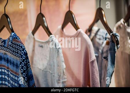 Damenbekleidung auf Kleiderbügeln in einem Einkaufszentrum - Einkaufen in mall-Konzept Stockfoto