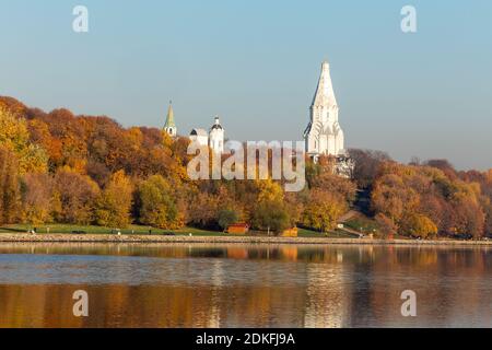 Farbenfroher Herbst. Gasse am Flussufer entlang im Hintergrund des Herbstparks. Reflexionen im Wasser des Waldes und des blauen Himmels. Die Kuppeln von Ort Stockfoto