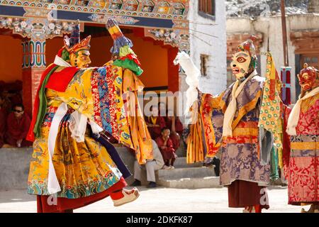 Lamayuru, Indien - 16. Juni 2012: Nicht identifizierte Mönche führen einen maskierten und kostümierten heiligen Tanz des tibetischen Buddhismus auf, andere Mönche spielen rituelle Musik du Stockfoto