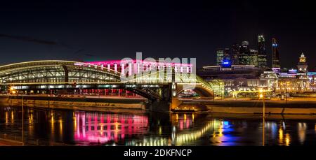 Nacht-Winterpanorama von der Moskwa-Ufer: Fußgängerbrücke Bogdan Khmelnitsky, Kiyevskaya Bahnhof, Stadt Moskau, Radisson Slavyans Stockfoto