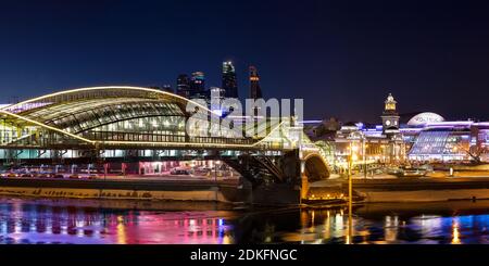 Nacht-Winterpanorama von der Moskwa-Ufer: Fußgängerbrücke Bogdan Khmelnitsky, Kiyevskaya Bahnhof, Stadt Moskau, Radisson Slavyans Stockfoto