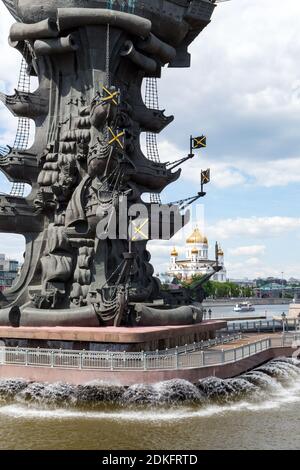 Fragment einer Statue von Peter dem Großen im Fluss Moskau, umgeben von Brunnen auf dem Hintergrund des Flusses mit Vergnügungsbooten und Kathedrale Stockfoto